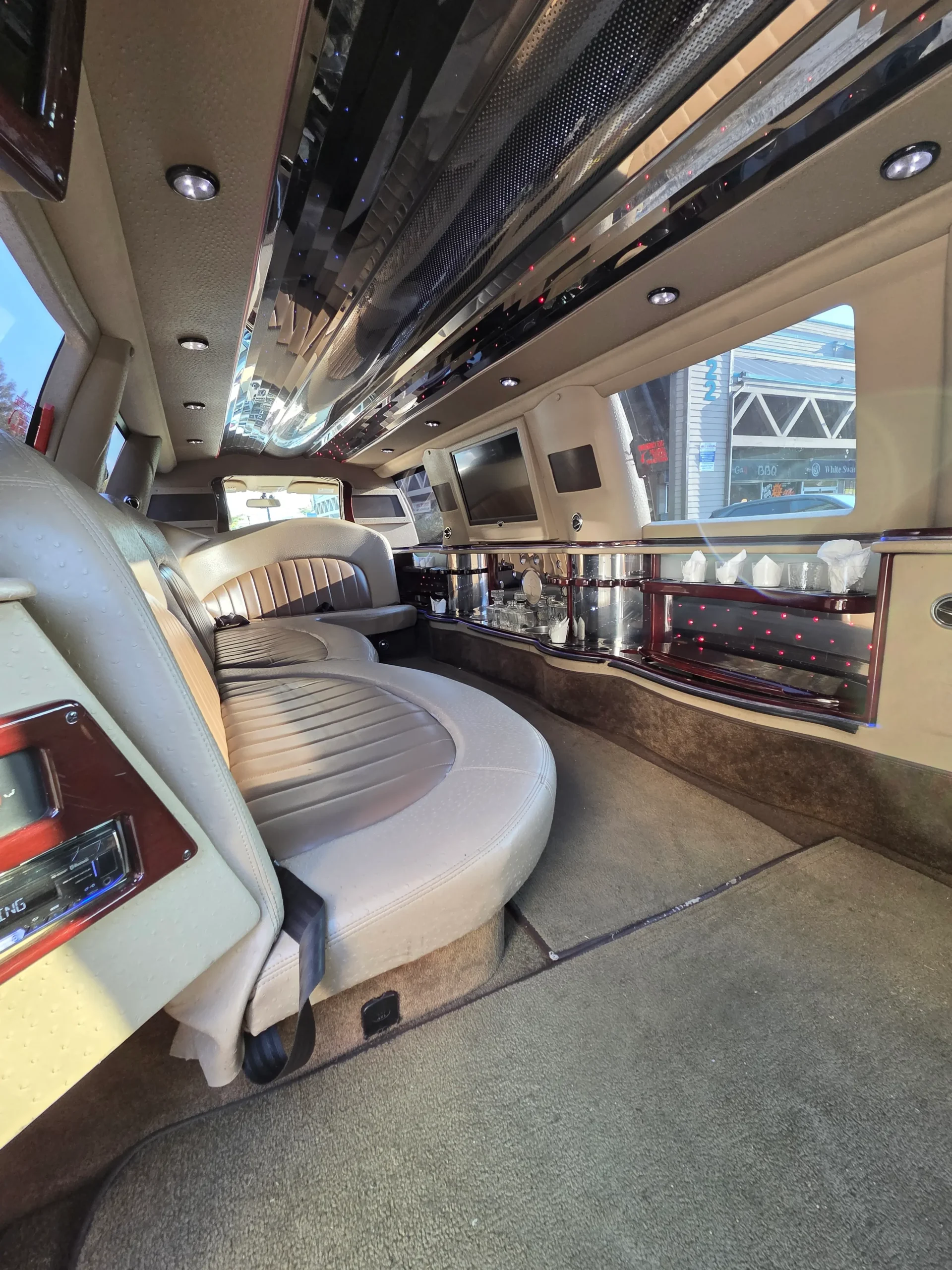 Cream leather interior of 12-passenger stretch SUV limo with starlight ceiling
