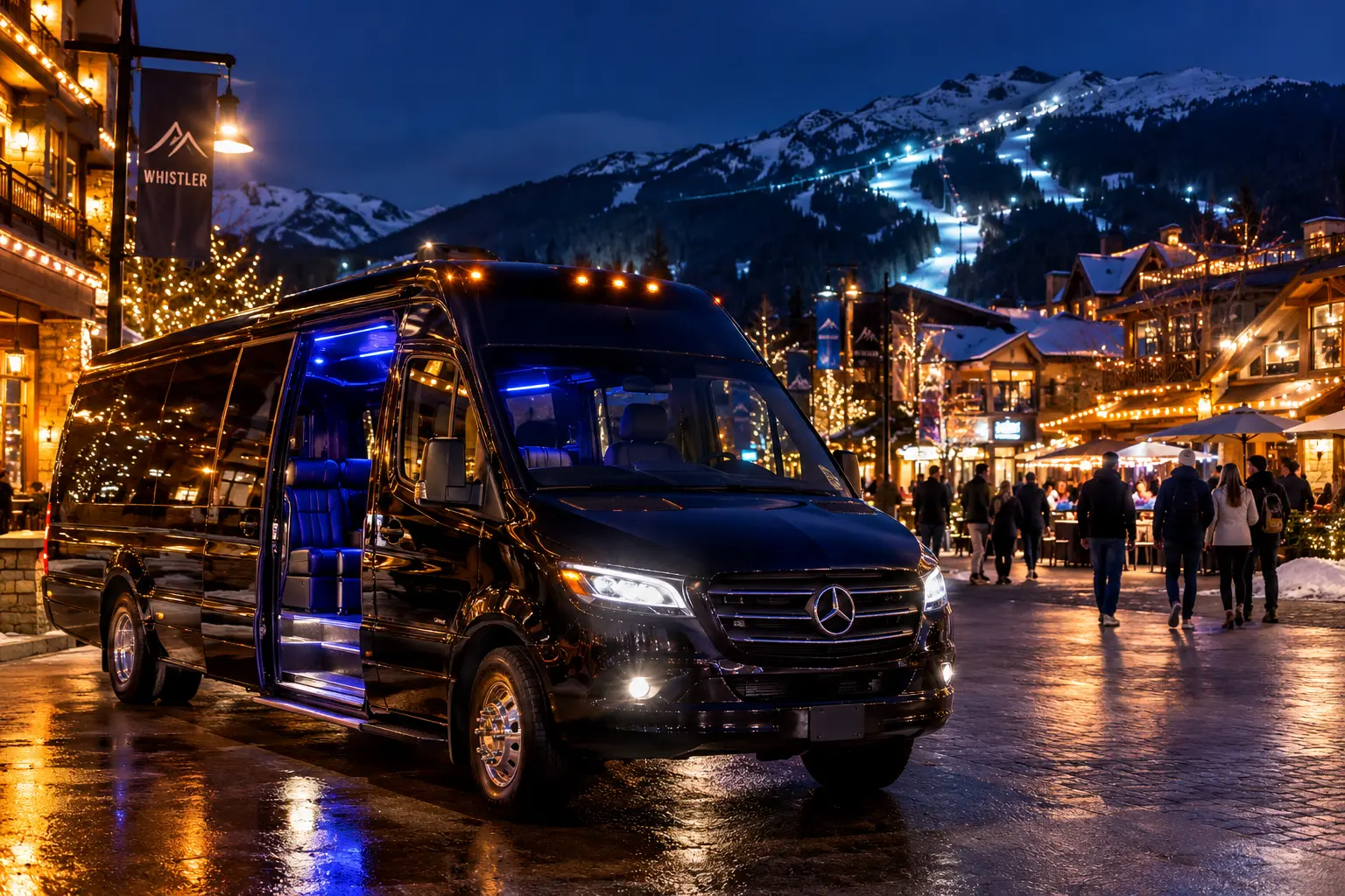 Black luxury Sprinter van with blue interior lighting in Whistler Village at night, surrounded by festive lights, pedestrians, and snowy mountains.